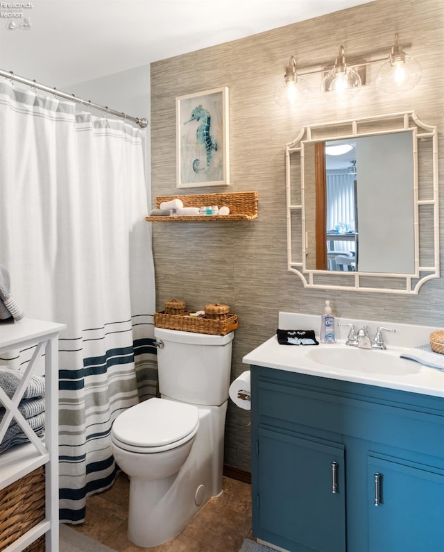 bathroom with a shower with shower curtain, vanity, and toilet