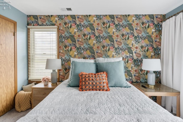 bedroom with carpet floors, multiple windows, visible vents, and wallpapered walls