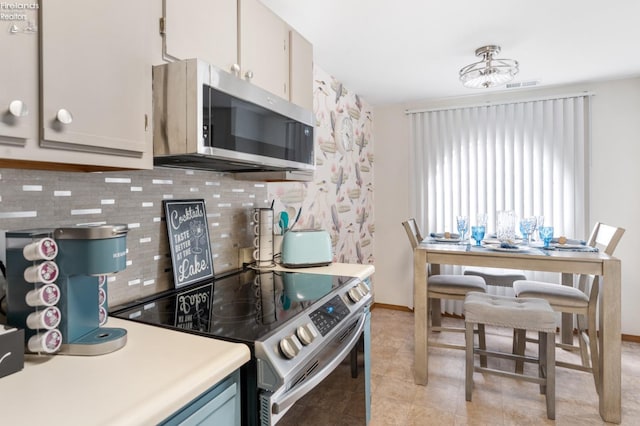 kitchen with light tile patterned floors, visible vents, light countertops, appliances with stainless steel finishes, and backsplash