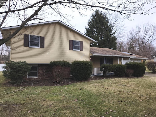 view of side of property with brick siding and a yard