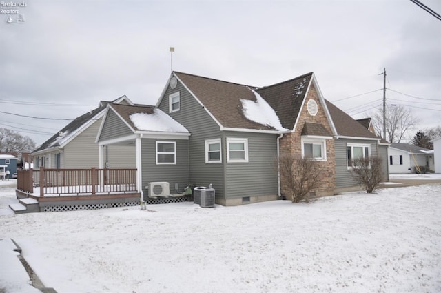 snow covered back of property featuring central air condition unit, roof with shingles, crawl space, a wooden deck, and ac unit