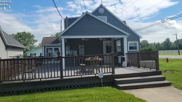 back of property featuring a ceiling fan, a yard, and a wooden deck