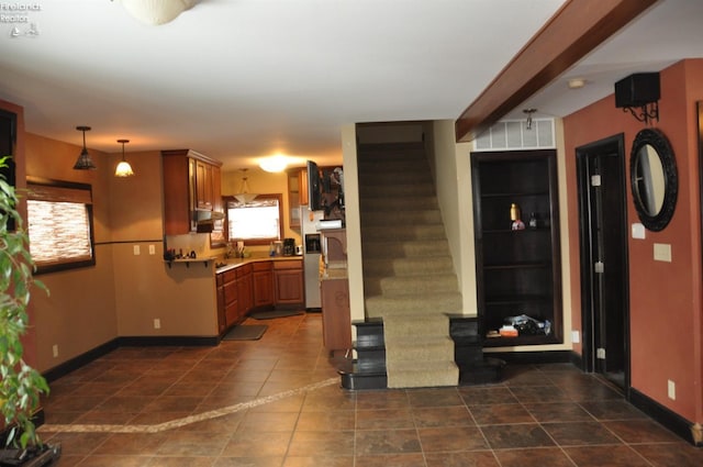 kitchen featuring brown cabinetry, baseboards, and light countertops