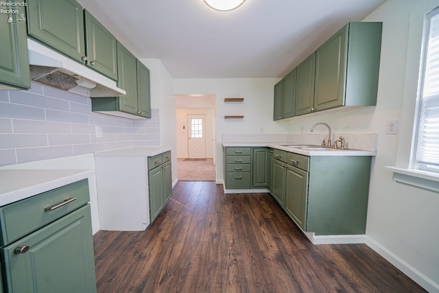 kitchen featuring dark wood-style floors, tasteful backsplash, a sink, and green cabinetry