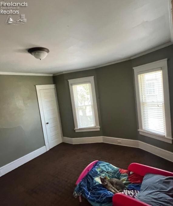 unfurnished bedroom with crown molding and baseboards