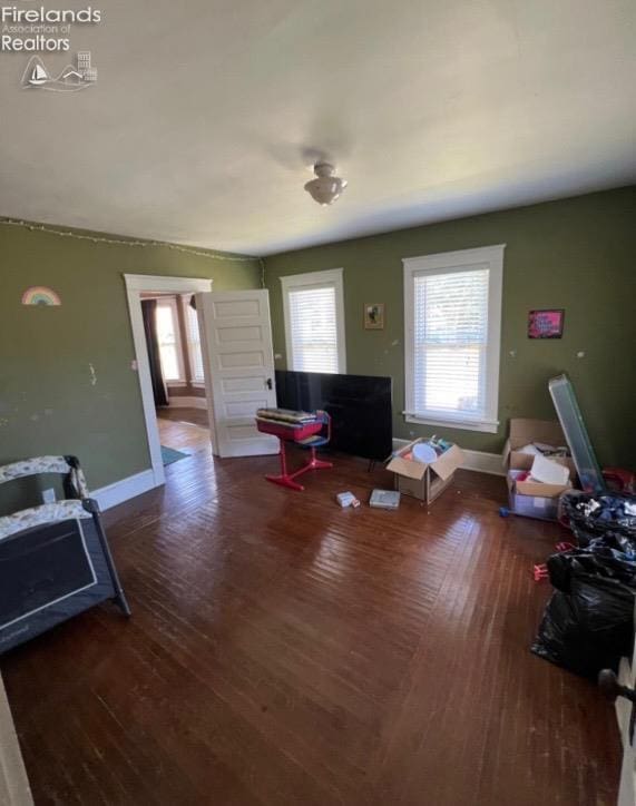 living area featuring baseboards and wood finished floors