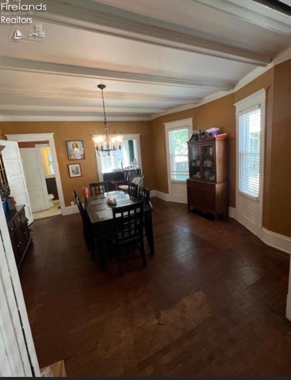 dining area featuring dark wood-style floors, beamed ceiling, a chandelier, and baseboards