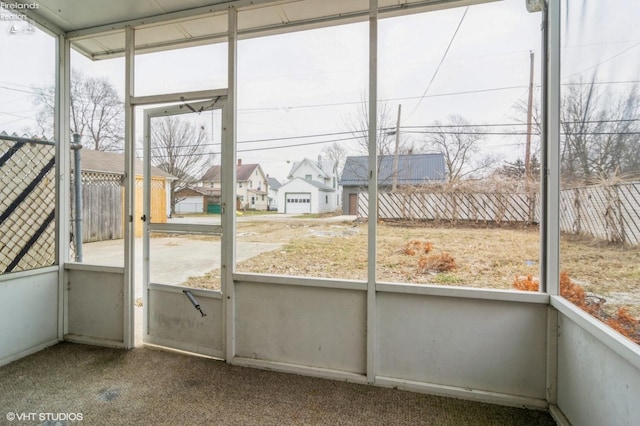 unfurnished sunroom with a residential view and a healthy amount of sunlight