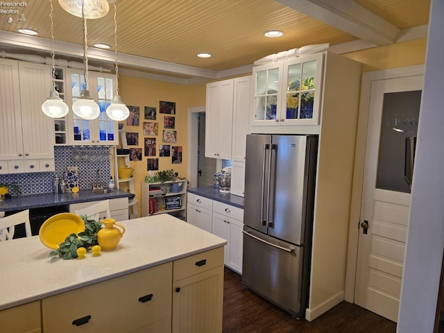 kitchen with tasteful backsplash, high quality fridge, glass insert cabinets, and dark wood-style flooring