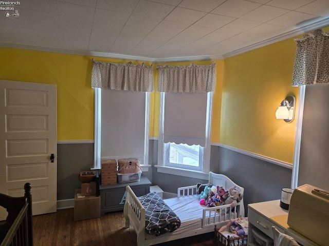 bedroom with crown molding and wood finished floors