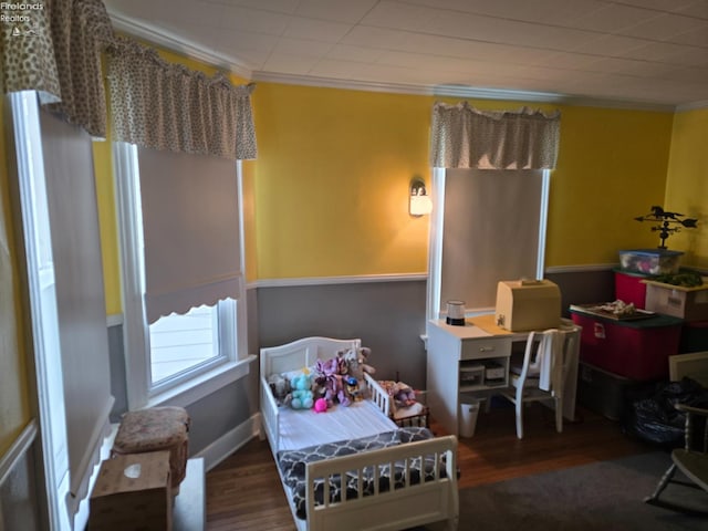 bedroom with crown molding and wood finished floors