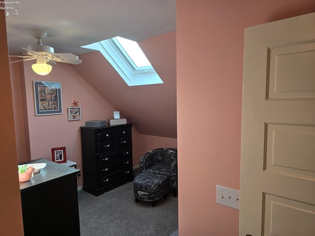 bedroom with carpet floors, vaulted ceiling with skylight, and a ceiling fan