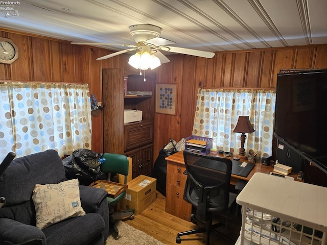 office with ceiling fan, wood walls, and light wood-type flooring