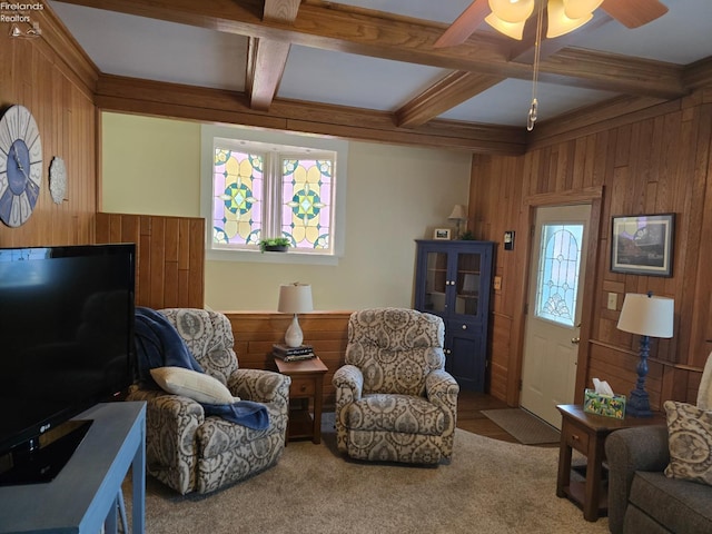 carpeted living area with coffered ceiling, wood walls, and beamed ceiling