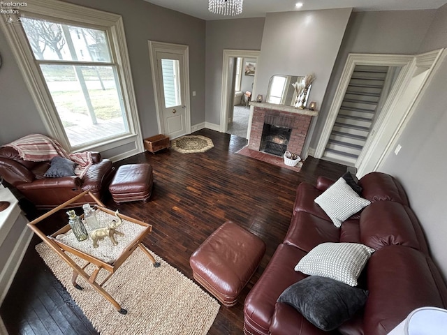 living area with a fireplace, hardwood / wood-style flooring, and baseboards