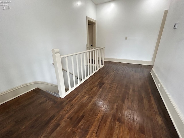 hallway featuring hardwood / wood-style flooring, baseboards, and an upstairs landing