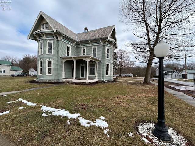 victorian-style house featuring a porch and a front yard