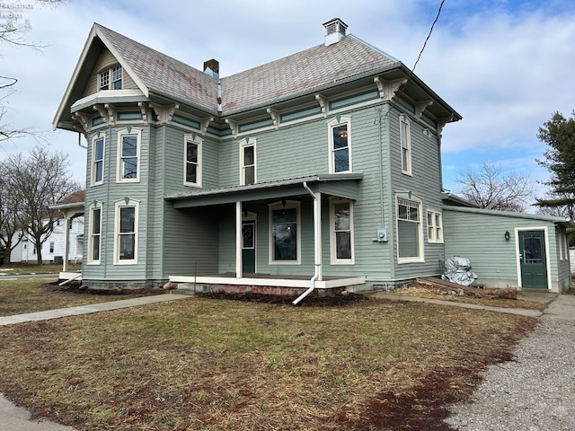 view of front of property featuring covered porch and a front lawn