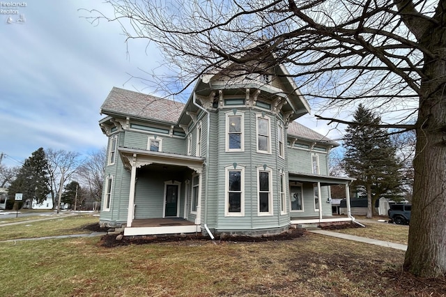 view of front of house featuring covered porch and a front lawn