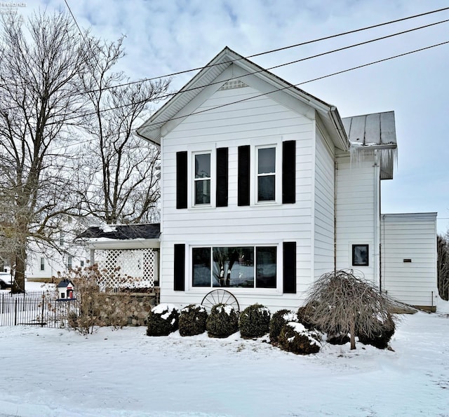 view of front of property with metal roof and fence