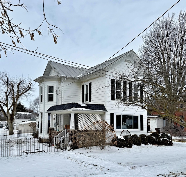 view of front of property featuring fence and metal roof