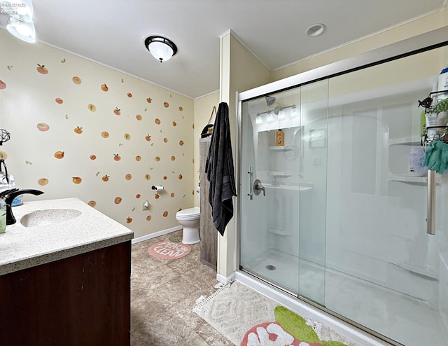 bathroom with toilet, a shower stall, baseboards, and vanity