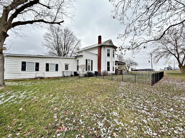 back of house featuring a yard, a chimney, and fence