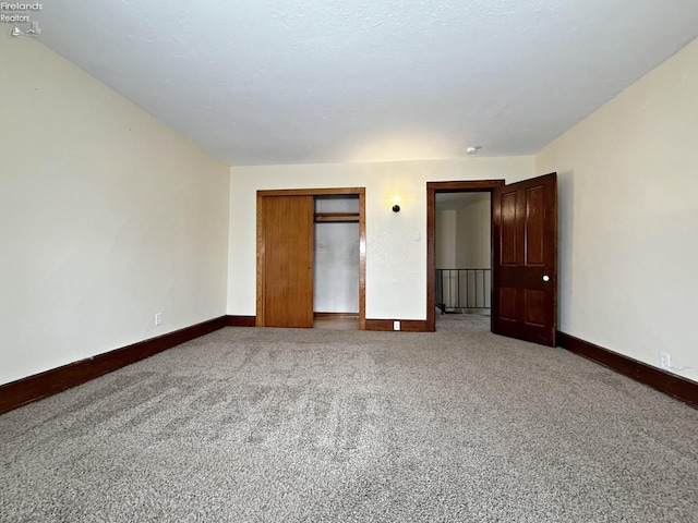 unfurnished bedroom with carpet floors, a closet, and baseboards