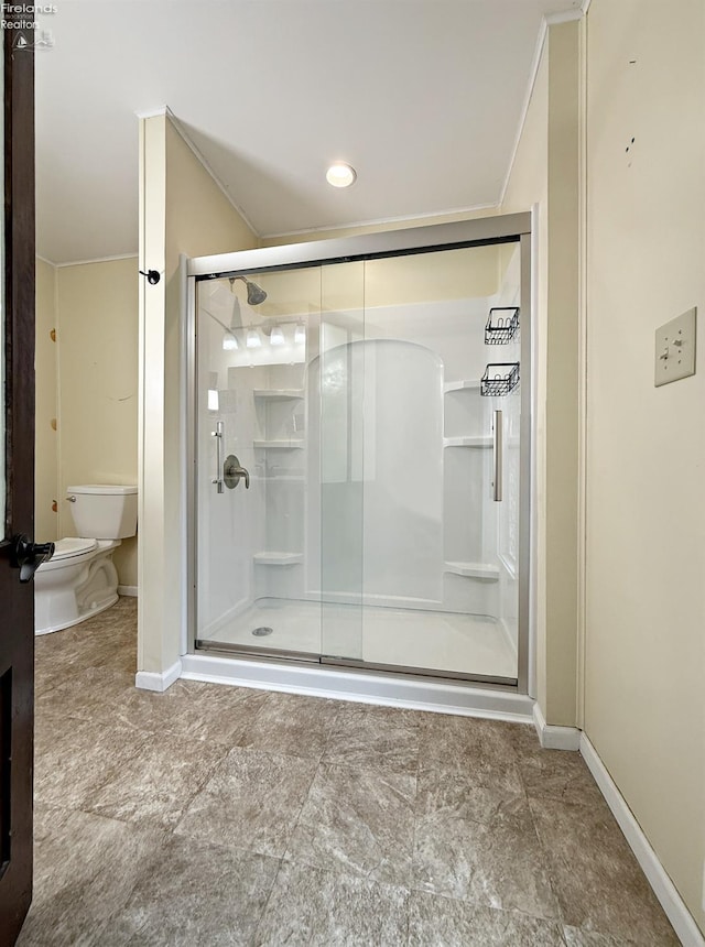 full bath featuring a stall shower, baseboards, and toilet