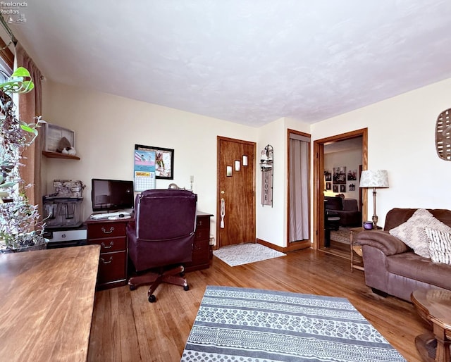 office area featuring baseboards and wood finished floors