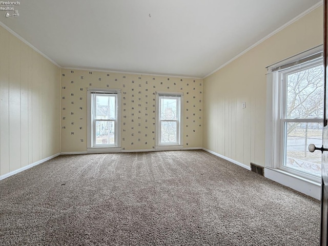 unfurnished room with carpet floors, baseboards, visible vents, and crown molding