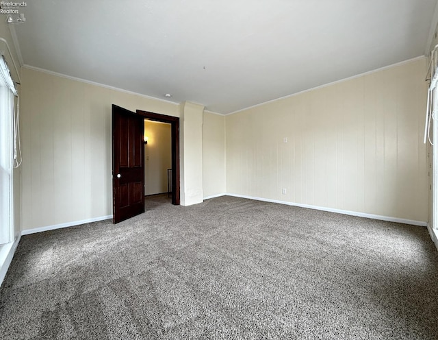 carpeted spare room with ornamental molding and baseboards