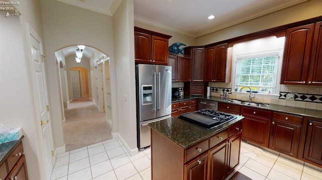 1876 N Lakewood Ave, Port Clinton, OH 43452 - kitchen with stainless steel fridge, arched walkways, decorative backsplash, crown molding, and a sink