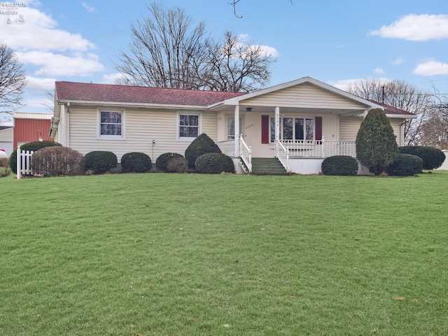 ranch-style home featuring covered porch and a front lawn