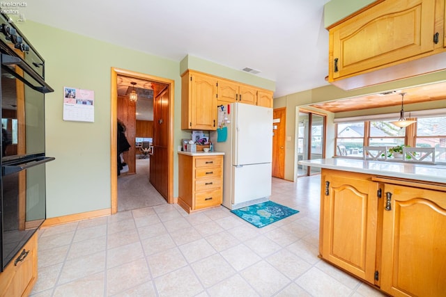 kitchen featuring visible vents, light countertops, freestanding refrigerator, and dobule oven black