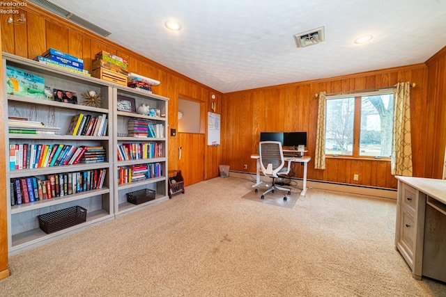 office space with visible vents, a baseboard radiator, carpet, crown molding, and wood walls