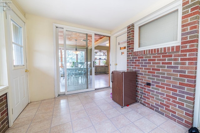 interior space featuring brick wall and light tile patterned floors