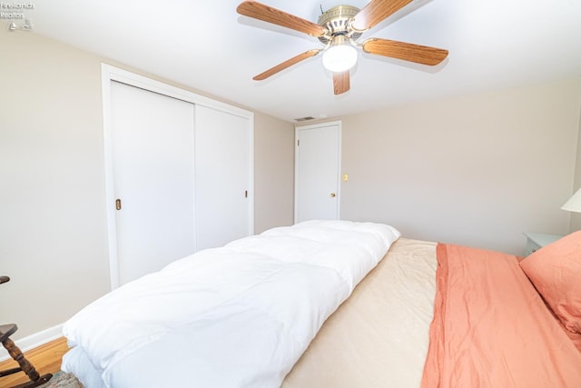 bedroom with light wood finished floors, baseboards, visible vents, a ceiling fan, and a closet