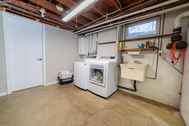 laundry area with washing machine and dryer, cabinet space, and a sink