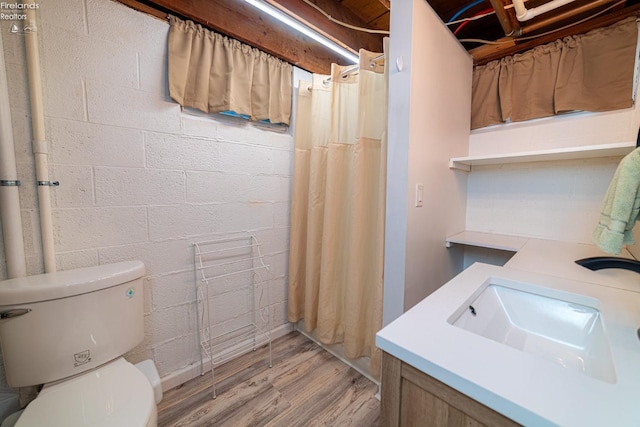 full bath featuring toilet, curtained shower, a sink, and wood finished floors