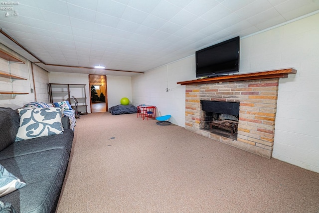 carpeted living area with concrete block wall and a fireplace