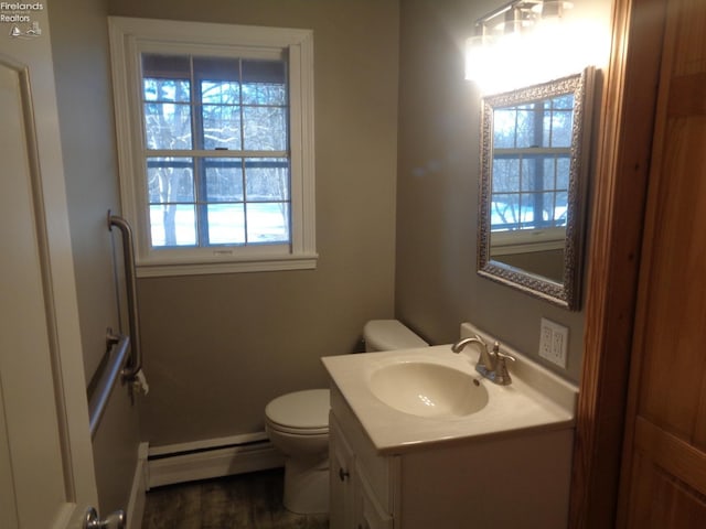 bathroom with baseboard heating, vanity, and toilet