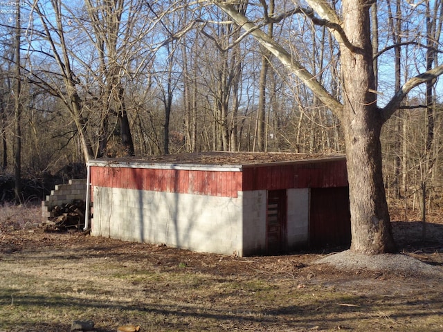 view of outbuilding with an outbuilding and a view of trees