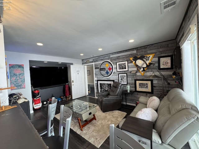 living area featuring recessed lighting, an accent wall, dark wood-type flooring, a fireplace, and visible vents