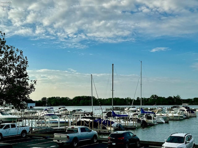 view of parking / parking lot featuring a dock and a water view