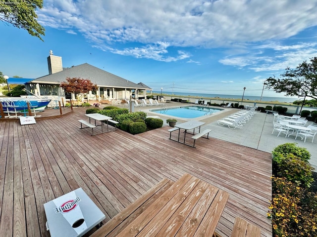 community pool featuring a patio and a wooden deck