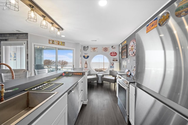 kitchen featuring a sink, white cabinets, appliances with stainless steel finishes, dark wood-style floors, and dark countertops