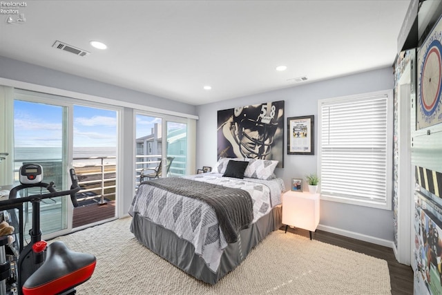 bedroom with baseboards, access to outside, visible vents, and wood finished floors