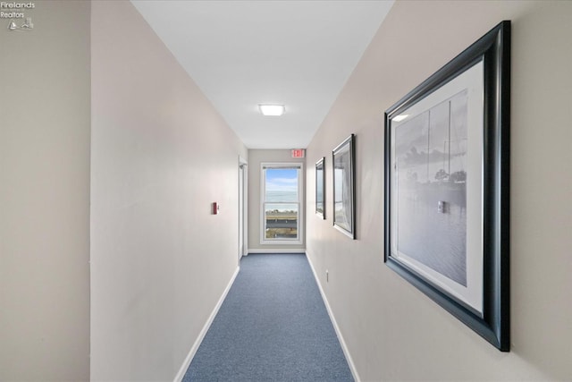 corridor with dark carpet and baseboards