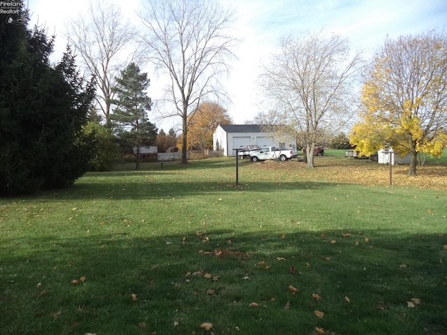 view of yard featuring a garage and an outdoor structure